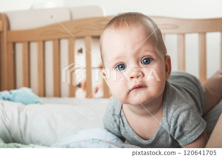 Curious Baby Standing in a Wooden Crib 120641705