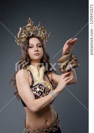Serpentine dancer showcasing art with snakes in a studio setting 120641873