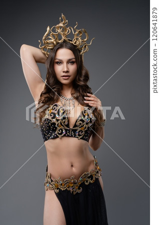 Elegant dancer showcases intricate costume with ornate details in studio 120641879