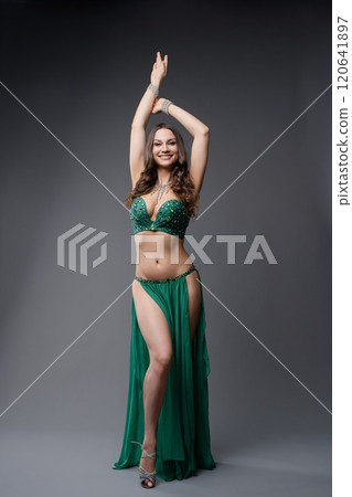 Belly dancer in green performs vibrant routine in the studio Belly dancer in green performs vibrant routine in the studio 120641897
