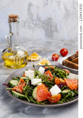 Salad with salmon, white cheese and vegetables on the plate with ingredients. Salad with salmon, white cheese and vegetables on the plate with ingredients. 120641950