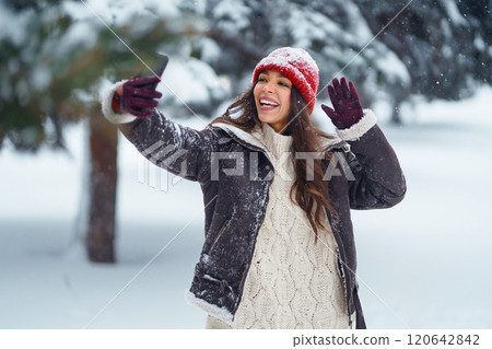 Cute woman enjoying the snowy landscape in the park. Concept of nature, technology. Cute woman enjoying the snowy landscape in the park. Concept of nature, technology. 120642842