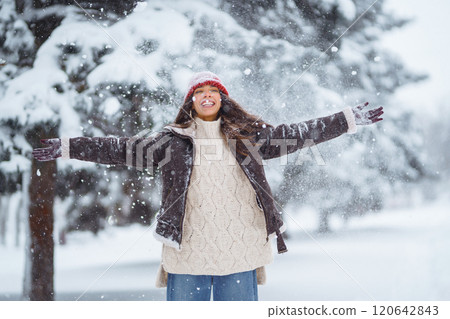 Young woman laughs and throws snow in a winter snowy park. Holidays, rest, travel concept. Young woman laughs and throws snow in a winter snowy park. Holidays, rest, travel concept. 120642843