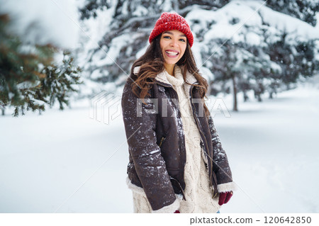 Young woman laughs and throws snow in a winter snowy park. Holidays, rest, travel concept. Young woman laughs and throws snow in a winter snowy park. Holidays, rest, travel concept. 120642850