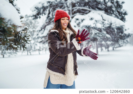 Young woman laughs and throws snow in a winter snowy park. Holidays, rest, travel concept. 120642860
