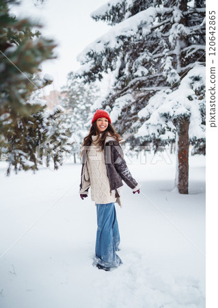Young woman laughs and throws snow in a winter snowy park. Holidays, rest, travel concept. 120642865