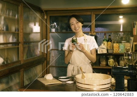 A middle-aged woman tying rice balls in the kitchen of an old-style house 120642883