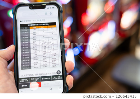 一名男子在智慧型手機上檢查彈珠機和老虎機數據 120643413