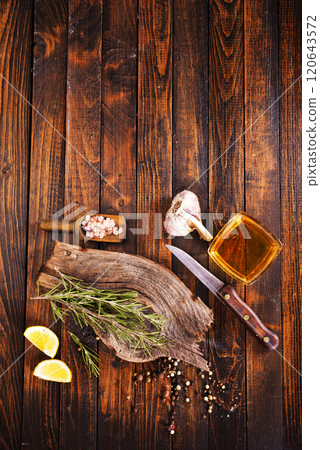 Rosemary sprig on a wooden kitchen table. Rosemary sprig on a wooden kitchen table. 120643572