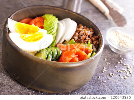 Healthy vegan nutritious bowl with buckwheat. Salad of avocado, salmon, buckwheat, egg and tomato, top view 120643580