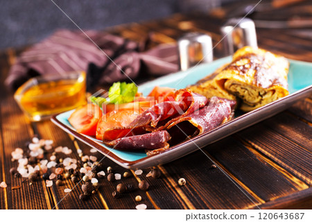 omelet with smoked meat, tomato and spice 120643687