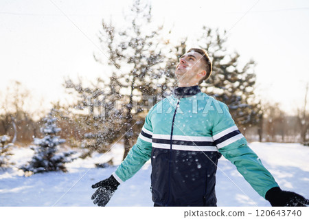 Young sportsman doing workout in forest at snowy winter day. Outdoor fitness, cardio exercises. 120643740