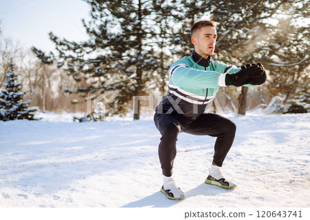 Young sportsman doing workout in forest at snowy winter day. Outdoor fitness, cardio exercises. 120643741