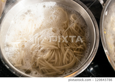 cooking udon noodles in steel pot at home 120643786