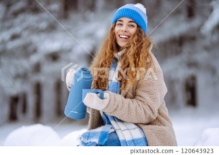 Young woman drinking a hot drink outdoors. Adventure concept. Lifestyle. 120643923