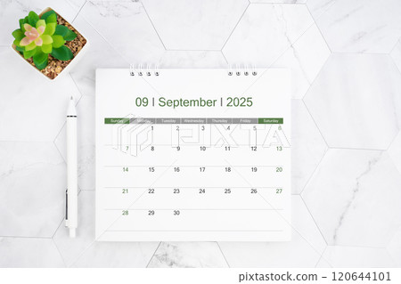 Desk calendar on month of September 2025 with pen on white marble background. Desk calendar on month of September 2025 with pen on white marble background. 120644101
