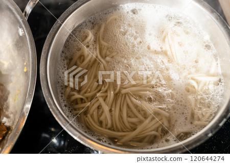 boiling udon noodles in steel pot at home 120644274