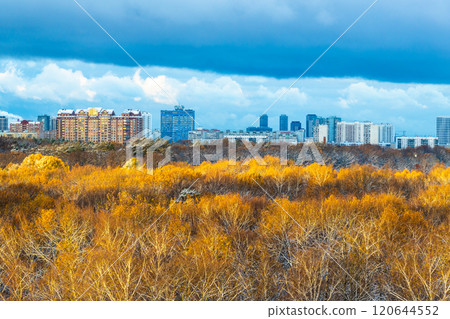 colorful city park lit by sun and dark snow cloud 120644552