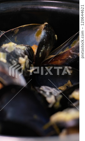 saucepan with mussels with cream sauce and tasty bread with garlic and spices on table of restaurant 120644621