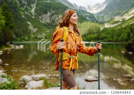 Travel Slovakia, Europe. Tourist with a yellow backpack stands against the backdrop of alpine lake. Travel Slovakia, Europe. Tourist with a yellow backpack stands against the backdrop of alpine lake. 120644843