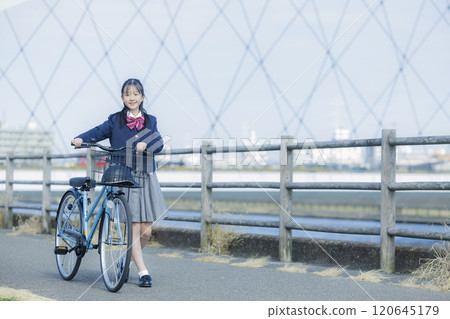 High school girl riding a bicycle on the riverbed High school girl riding a bicycle on the riverbed 120645179