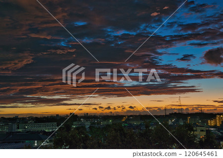 Clouds illuminated by the morning sun. Morning glow spreading over a residential area. Sunrise. Morning in a residential area. Early morning. Morning glow. Morning sun. Sun. 120645461
