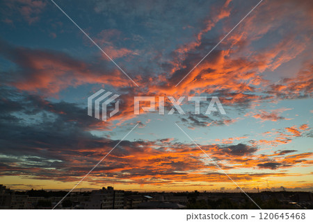 Clouds illuminated by the morning sun. Morning glow spreading over a residential area. Sunrise. Morning in a residential area. Early morning. Morning glow. Morning sun. Sun. 120645468