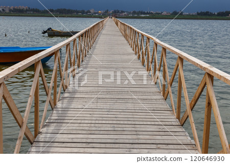 Wooden walkway leads to the Caspian Sea in Iran with boats and cityscape visible Wooden walkway leads to the Caspian Sea in Iran with boats and cityscape visible 120646930