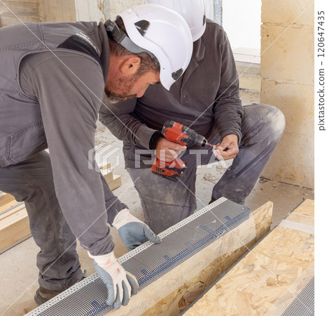 Carpenters working on wooden board using professional electric cordless screwdriver Carpenters working on wooden board using professional electric cordless screwdriver 120647435