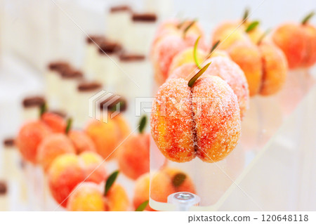 Vibrant peach shaped sweets are delicately arranged in pastry showcasing artistry of dessert creation during event occasion atmosphere Vibrant peach shaped sweets are delicately arranged in pastry showcasing artistry of dessert creation during event occasion atmosphere 120648118