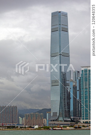 Skyscraper in a cloudy urban skyline, blending modern architecture with dramatic weather contrasts Skyscraper in a cloudy urban skyline, blending modern architecture with dramatic weather contrasts 120648355