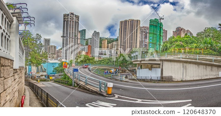 Dense urban architecture in Hong Kong with tightly packed high-rise buildings under a bright sky 120648370