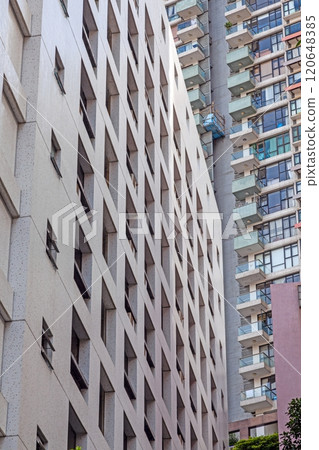 Modern high-rise facade with repeating geometric balconies creating a minimal and abstract urban pattern Modern high-rise facade with repeating geometric balconies creating a minimal and abstract urban pattern 120648385