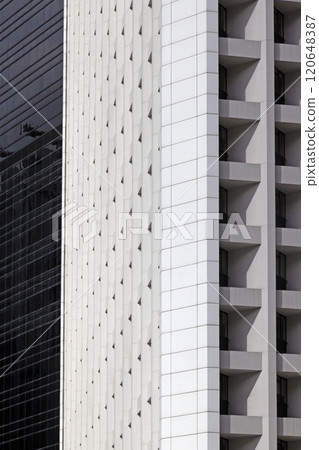 Modern high-rise facade with repeating geometric balconies creating a minimal and abstract urban pattern Modern high-rise facade with repeating geometric balconies creating a minimal and abstract urban pattern 120648387