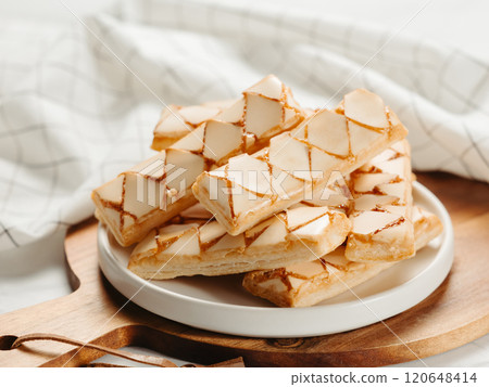 Italian crispy sweet bakery Sfogliatine glassate over white marble table surface. Tasty breakfast with apricot glaze puff pastries. 120648414