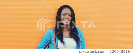 Portrait of happy stylish young african woman in casual clothing, glasses posing in the city 120648916