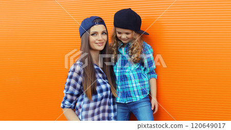 Stylish mother and child daughter together, happy mom with kid girl in casual clothing in the city Stylish mother and child daughter together, happy mom with kid girl in casual clothing in the city 120649017
