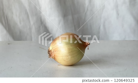 Fresh onion placed on a clean surface for cooking preparation Fresh onion placed on a clean surface for cooking preparation 120649325