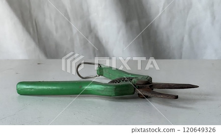 Vintage green scissors resting on a simple white surface indoors Vintage green scissors resting on a simple white surface indoors 120649326