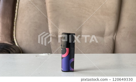 Lighter stands on a table in a cozy indoor setting Lighter stands on a table in a cozy indoor setting 120649330
