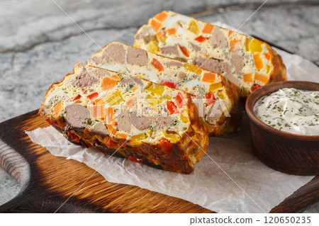 Spicy terrine pie with chicken liver, carrots, peppers, herbs and eggs close-up on a wooden board. Horizontal Spicy terrine pie with chicken liver, carrots, peppers, herbs and eggs close-up on a wooden board. Horizontal 120650235