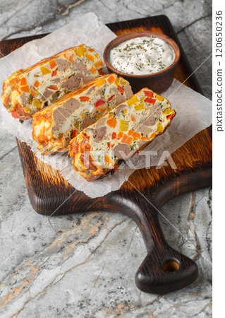 Chicken liver casserole with carrots, peppers, herbs and eggs close-up on a wooden board. Vertical Chicken liver casserole with carrots, peppers, herbs and eggs close-up on a wooden board. Vertical 120650236