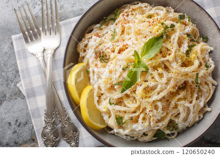 Italian Pasta with ricotta, parmesan, extra virgin olive oil, garlic, lemon zest, basil and pepper closeup on the plate. Horizontal top view 120650240