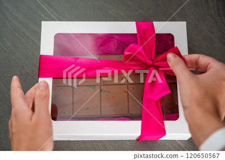 Trend Dubai chocolate with pistachio paste and kataifi dough in present box. Confectionery handmade sweets at home in the kitchen.  120650567