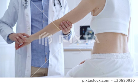 Doctor man examines a patient's elbow during a medical consultation in a clinic. The concept of medicine and orthopedics 120650930