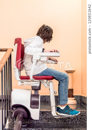 Child Using Stairlift on Indoor Staircase Child Using Stairlift on Indoor Staircase 120651642