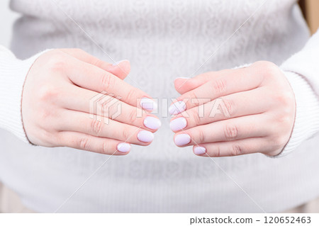 Stylish lavender manicure on the nails of a young woman. 120652463