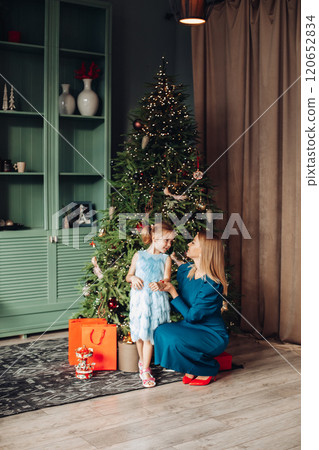 Little girl and her mom on Christmas morning at 120652834