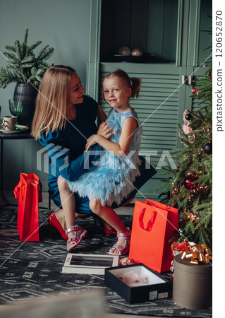 Little girl and her mom on Christmas morning at 120652870