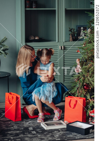 Little girl and her mom on Christmas morning at 120652872